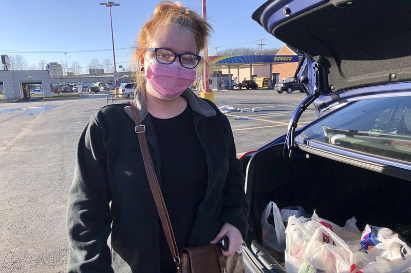 Hairdresser Chelsea Woody stands outside her car at a grocery store Tuesday, Jan. 11, 2022, in Charleston, W.Va. For the first time in half a year, families on Jan. 14, are going without a monthly deposit from the federal child tax credit. Woody, a single mother, relied on the check to help raise her young son. (AP Photo/John Raby)


