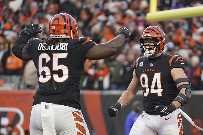 AP photo by Jeff Dean / Cincinnati Bengals defensive linemen Larry Ogunjobi (65) and Sam Hubbard celebrate after Hubbard sacked Las Vegas Raiders quarterback Derek Carr during the first half of Saturday's AFC wild-card playoff game in Cincinnati.