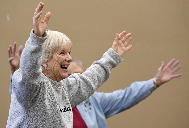 Staff Photo by Matt Hamilton / Dottie Neuf raises her hands in the air as part of the "Fit and Flex" program hosted by the Collegedale Parks and Recreation Department at the Collegedale Community Center on Friday, January 14, 2022. 