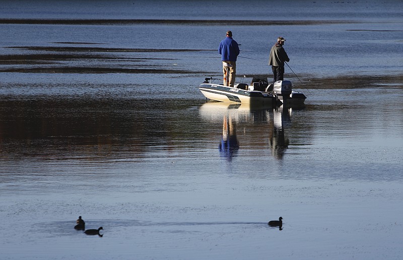 Staff file photo by Dan Henry / Fishermen work their way around a cove near the marina at Harrison Bay State Park as American coots float nearby.