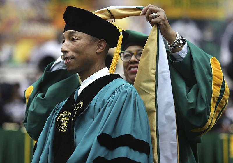 Norfolk State University President Javaune Adams-Gaston bestows Pharrell Williams with an honorary doctorate after he gave the commencement speech, Saturday, Dec. 11, 2021, in Norfolk, Va. In remarks made Monday, Jan. 17, 2022, during the Urban League of Hampton Roads' annual Martin Luther King Jr. awards program, singer and music producer Williams challenged corporate America to "do more" by supporting entrepreneurs of color and adopting economic equity measures. (Stephen M. Katz/The Virginian-Pilot via AP, File)