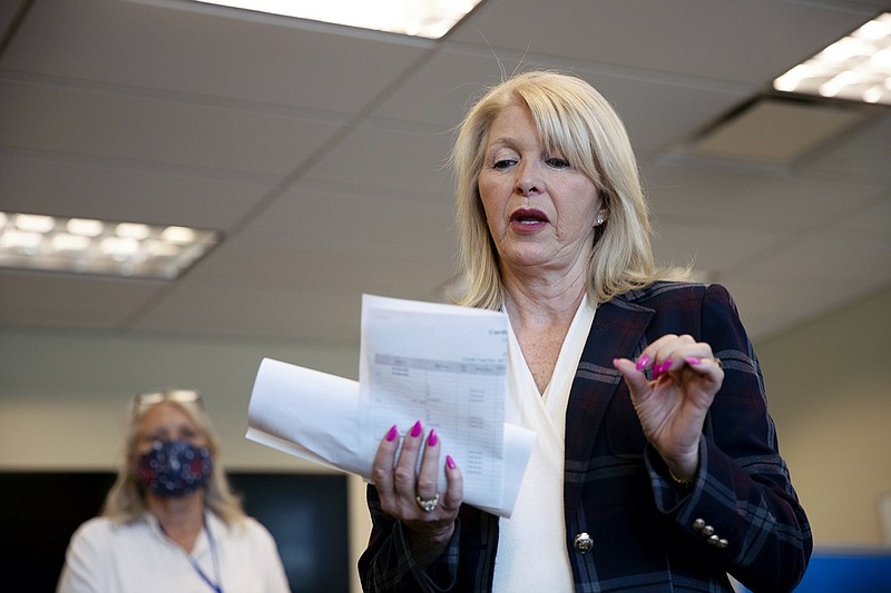 FILE - In this June 30, 2020, file photo, Mesa County Clerk Tina Peters reads an update on the election in Grand Junction, Colo. Colorado's secretary of state has filed a lawsuit, Tuesday, Jan. 18, 2022, asking a judge to remove Peters from administering the 2022 election. The action comes amid federal and state investigations into an alleged breach of security involving election equipment in the western Colorado county last year. (McKenzie Lange/The Grand Junction Daily Sentinel via AP, File)