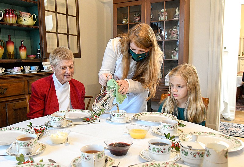 Photo by Mark Gilliland / Lilly Waters pours tea for Belinda Mitchell (left) and Eloise McElhaney.
