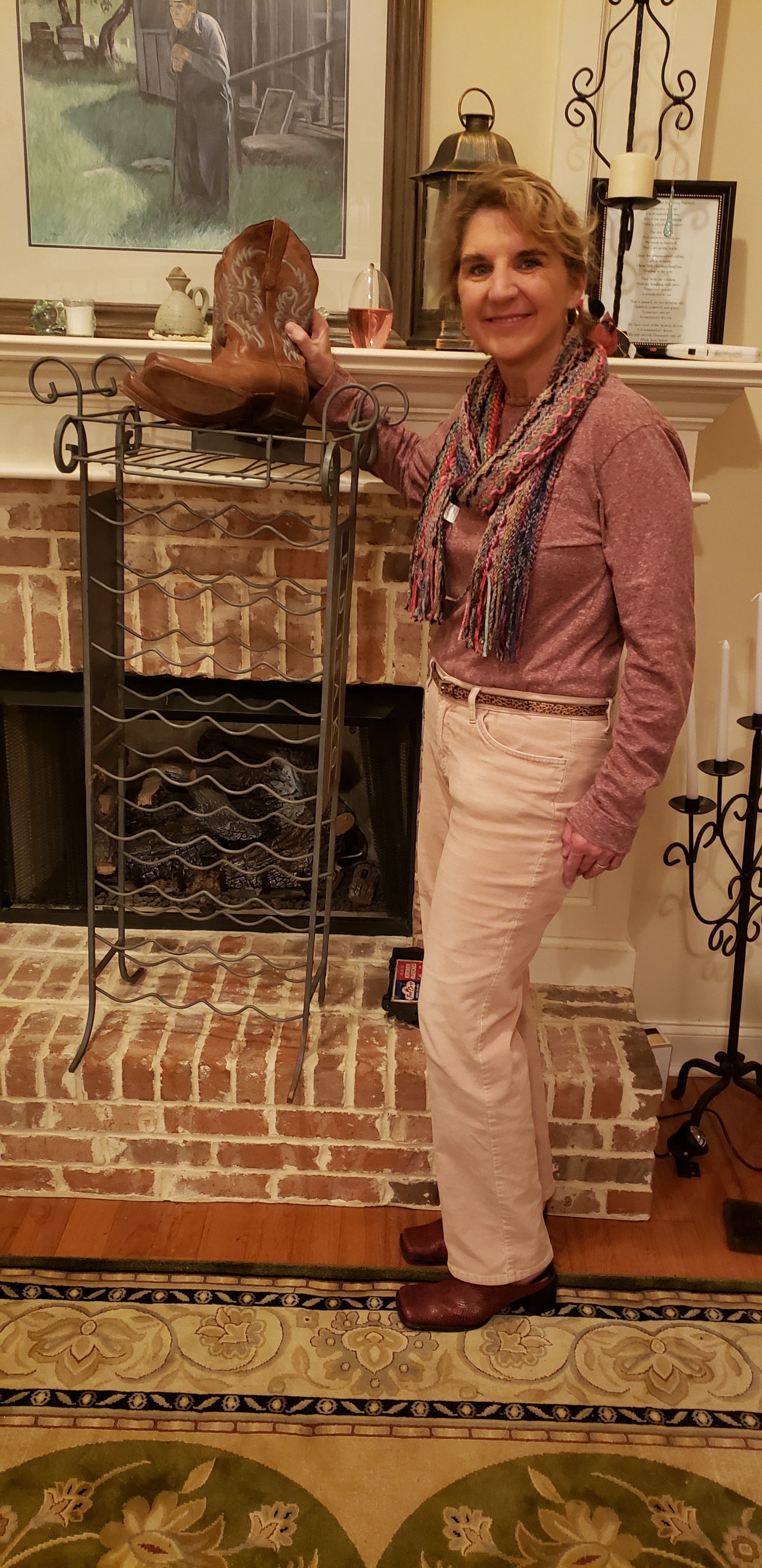 Photo contributed by Dee Hartwell / Dee Hartwell shows off a pair of cowboy boots and a wine rack she found while visiting antique stores, an activity she likes to schedule work trips around.