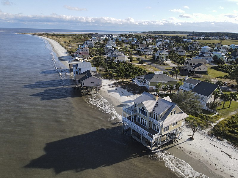 File photo by Rebecca Blackwell of The Associated Press / Water laps the bottom level of four homes in Harbor Island, S.C., on Oct. 30, 2021, which had to be abandoned after years of beach erosion and damage from Hurricane Matthew in 2016. Democratic and Republican governors alike want to spend money on projects aimed at slowing climate change and guarding against its consequences, from floods and fires to cleaning up dirty air.