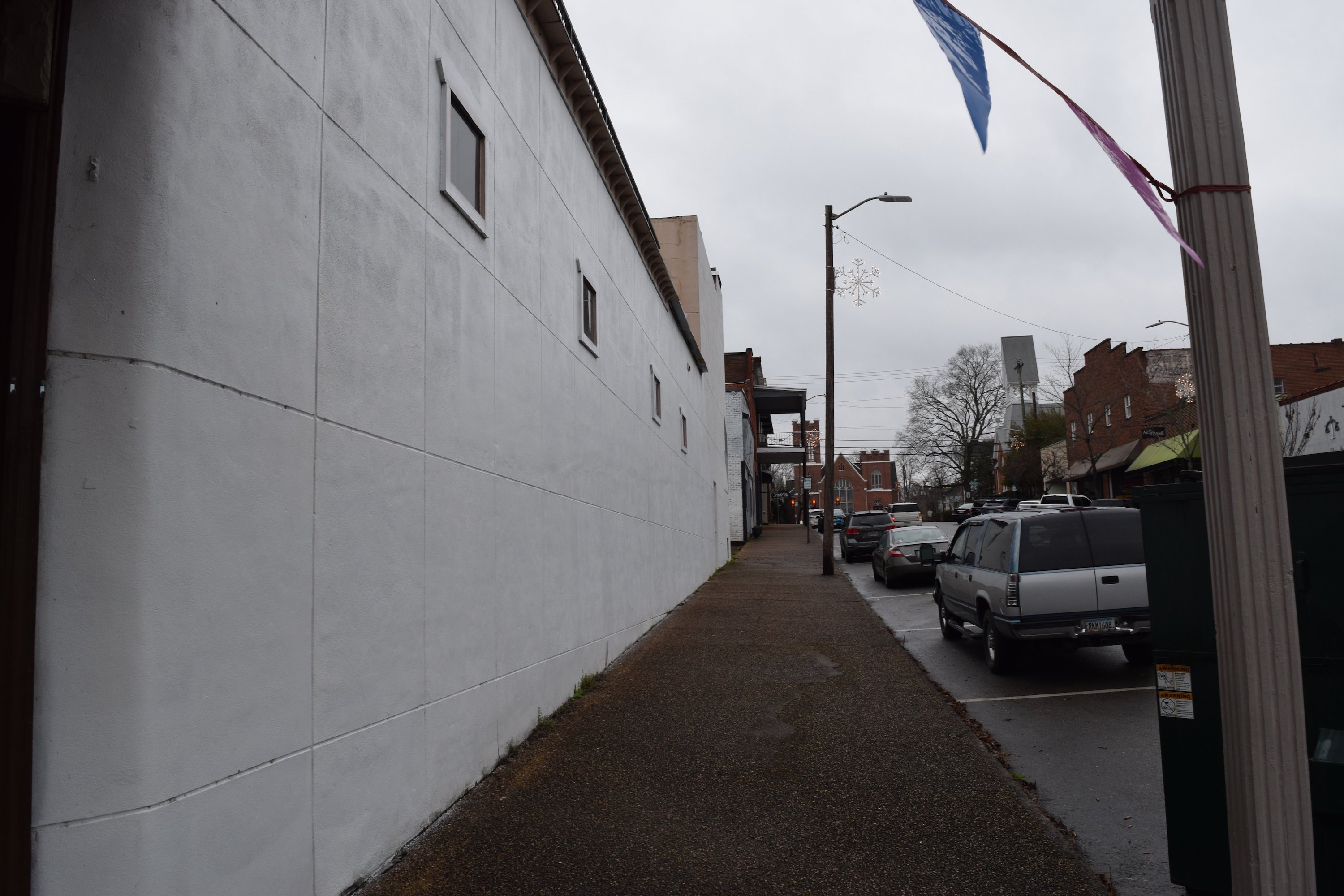 Staff photo by Ben Benton / A sign painted in 2019 on the side of Glenn Whiting's family's building on the McMinn County Courthouse square critical of the city of Athens, Tenn., and its police department led to a federal free speech lawsuit that ended in a mistrial on Tuesday. The sign has since been painted over.
