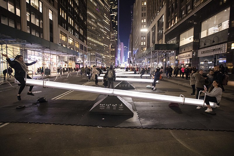 People on Impulse seesaws between 37th and 38th Streets in New York on Jan. 24, 2020. The set of playground-inspired contraptions, known as Impulse, is the latest installation in the garment district Alliance's yearlong public art program. (Benjamin Norman/The New York Times)