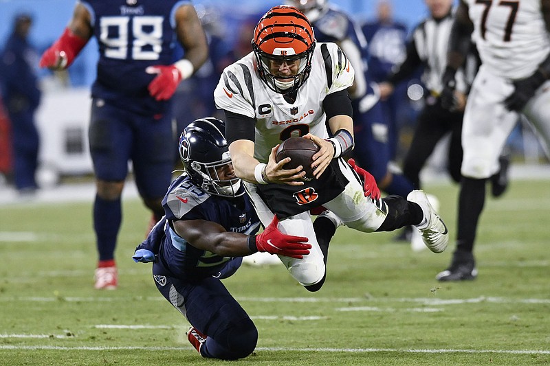 AP photo by Mark Zaleski / Cincinnati Bengals quarterback Joe Burrow leaps for a first down past Tennessee Titans inside linebacker Jayon Brown during the second half of an AFC divisional round playoff game Saturday in Nashville.