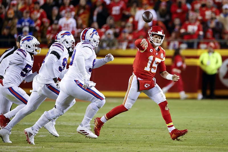 Kansas City Chiefs quarterback Patrick Mahomes (15) throws a pass on the run as he is chased by Buffalo Bills defenders during the second half of an NFL divisional round playoff football game, Sunday, Jan. 23, 2022, in Kansas City, Mo. (AP Photo/Colin E. Braley)