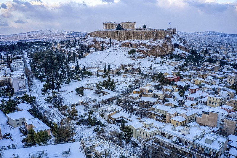 The city of Athens with the ancient Acropolis hill is covered with snow after heavy snowfall on Tuesday, Jan. 25, 2022. A snowstorm of rare severity disrupted road and air traffic Monday in the Greek capital of Athens and neighboring Turkey's largest city of Istanbul, while most of Greece, including — unusually — several Aegean islands, and much of Turkey were blanketed by snow. (Antonis Nikolopoulos/Eurokinissi via AP)