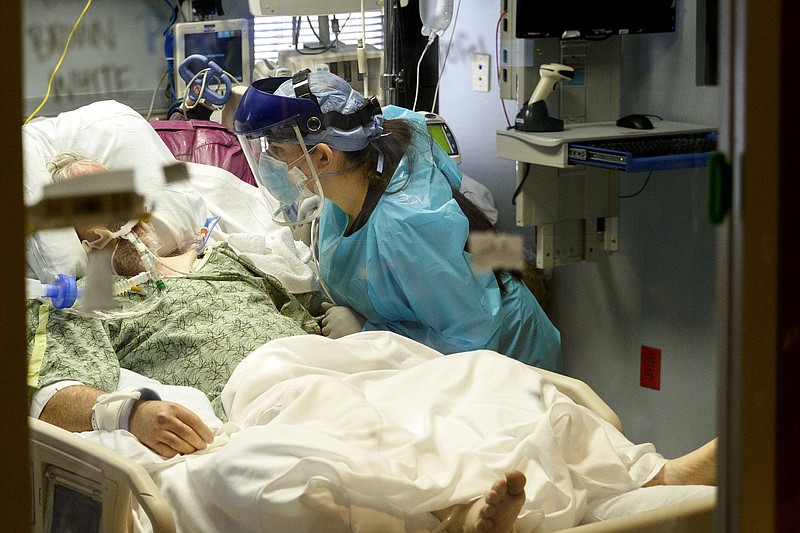 Staff photo / Occupational therapist Cori Cohen works with a patient inside the COVID-19 intensive care unit at Erlanger on Monday, Feb. 22, 2021, in Chattanooga, Tenn.