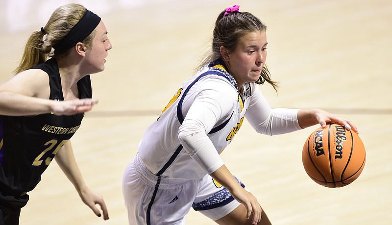 Staff photo by Robin Rudd / UTC freshman guard Addie Grace Porter dribbles past Western Carolina's Bailey Trumm during a SoCon game at McKenzie Arena on Jan. 20.