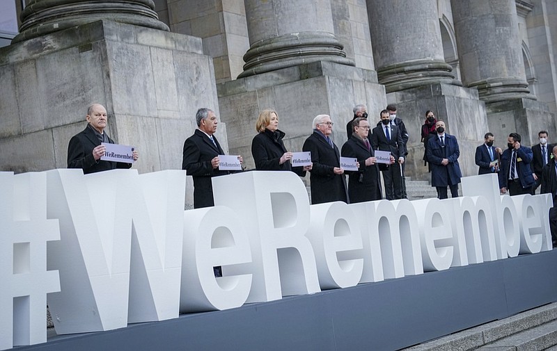 German Chancellor Olaf Scholz, Mickey Levy, Speaker of the Knesset, Bärbel Bas, President of the Bundestag, German President Frank-Walter Steinmeier and Bodo Ramelow, Prime Minister of Thuringia and President of the Bundesrat, from left, stand in front of the Reichstag building after the memorial hour for the "Day of Remembrance of the Victims of National Socialism" at the lettering "#weremember" (We remember) in Berlin, Germany, Thursday, Jan.27, 2022. (Kay Nietfeld/dpa via AP)