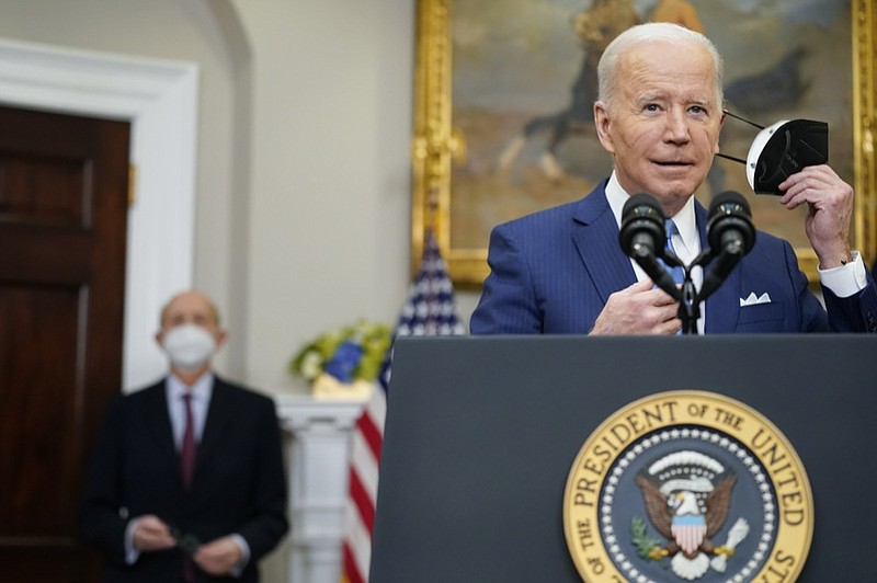 President Joe Biden removes his face mask as he prepares to deliver remarks on the retirement of Supreme Court Associate Justice Stephen Breyer, left, in the Roosevelt Room of the White House in Washington, Thursday, Jan. 27, 2022. (AP Photo/Andrew Harnik)


