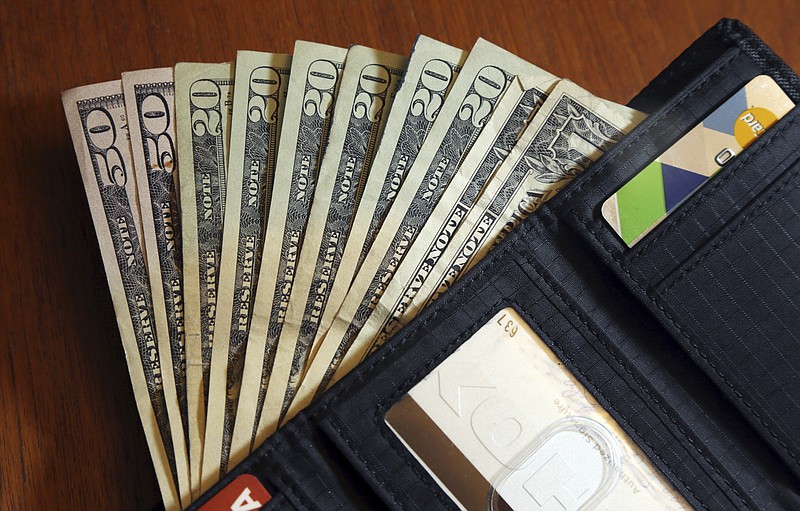 FILE - In this June 15, 2018, file photo, cash is fanned out from a wallet in North Andover, Mass. Spend enough time in the personal finance corners of social media and you're bound to come across someone talking about how much passive income they make — and it's likely they make it sound pretty easy. (AP Photo/Elise Amendola, File)