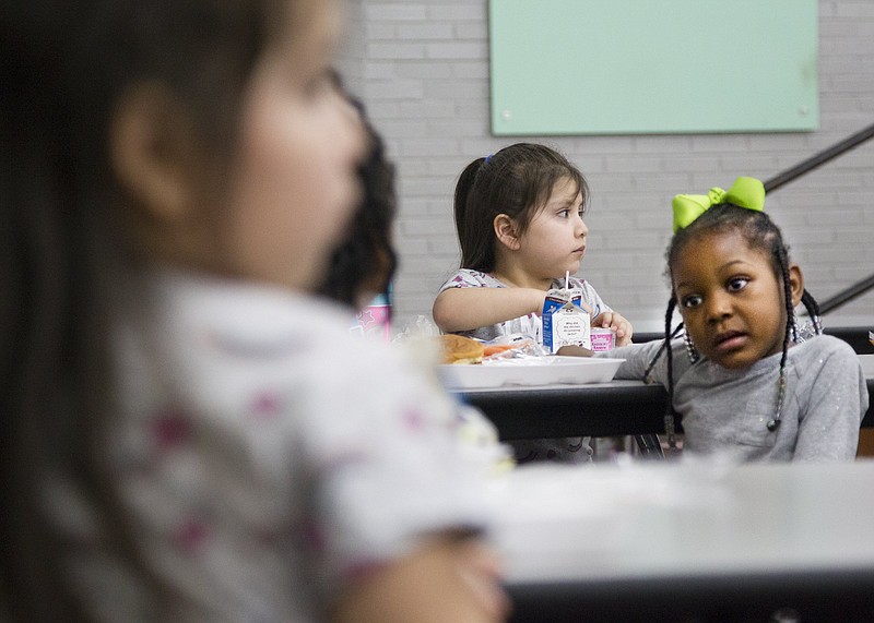 Staff file photo / Pre-k students Kimora Turner, 5, right, and Melody Perez, 5, center, eat their lunch at Rivermont Elementary School on Friday, March 13, 2020, in Chattanooga, Tenn.