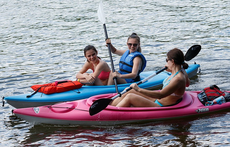 Staff photo by Doug Strickland / Trinity Smith, left, and her sister Madison, center, kayak with their aunt, Leanne Lipps, at Harrison Bay State Park on Thursday, June 13, 2019, in Harrison, Tenn.