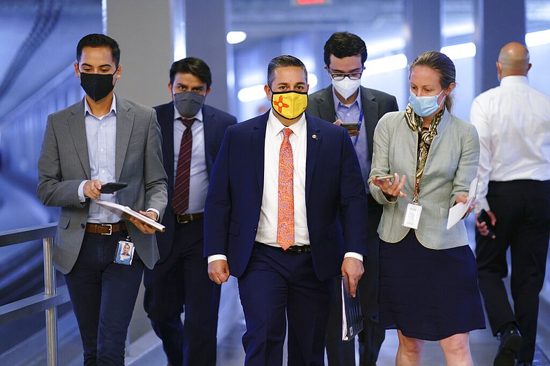 Sen. Ben Ray Lujan, D-N.M., center, arrives for votes on amendments to advance the $1 trillion bipartisan infrastructure bill, at the Capitol in Washington, Wednesday, Aug. 4, 2021. Lujan is recovering at an Albuquerque hospital after suffering a stroke last week, his office said in a statement issued Tuesday, Feb. 1, 2022. Until he recovers, Democrats would have just 49 votes compared to Republicans' 50, assuming all other senators are healthy. (AP Photo/J. Scott Applewhite, File)