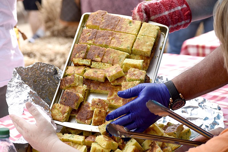 Staff File Photo by Robin Rudd / Chefs from Richard Hardy Memorial School Athletics empty out another tray of their parmesan chive cornbread in Cornbread Alley during a previous National Cornbread Festival in South Pittsburg, Tenn.