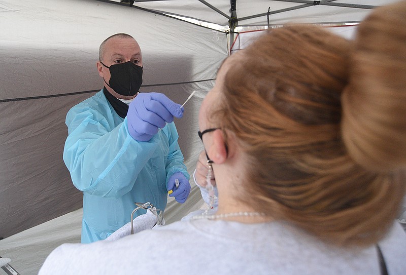 Staff Photo by Matt Hamilton / Greg Roberts takes a nasal swab for a COVID-19 test at a temporary community testing site set up by Athena Esoterix on Signal Mountain Road on Thursday, January 6, 2022.