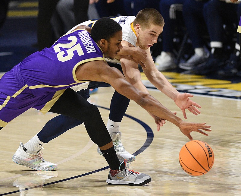 Staff photo by Matt Hamilton / Western Carolina's Nicholas Robinson, left, and UTC's Grant Ledford battle for a loose ball during Wednesday night's SoCon game at McKenzie Arena.