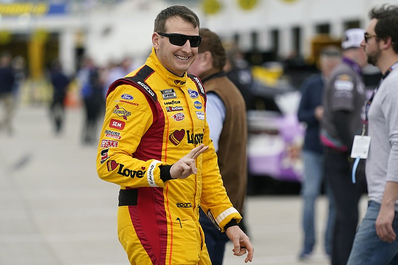 Michael McDowell waves to a friend near his garage at NASCAR auto race practice at Daytona International Speedway, Tuesday, Feb. 15, 2022, in Daytona Beach, Fla. (AP Photo/John Raoux)