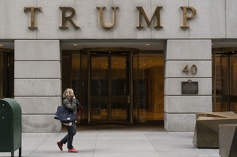 File photo by Mark Lennihan of The Associated Press / A woman walks past the Trump Building in New York's financial district on Jan. 13, 2021. Mazars USA LLP, the accounting firm that prepared former President Donald Trump's annual financial statements, says the documents "should no longer be relied upon."