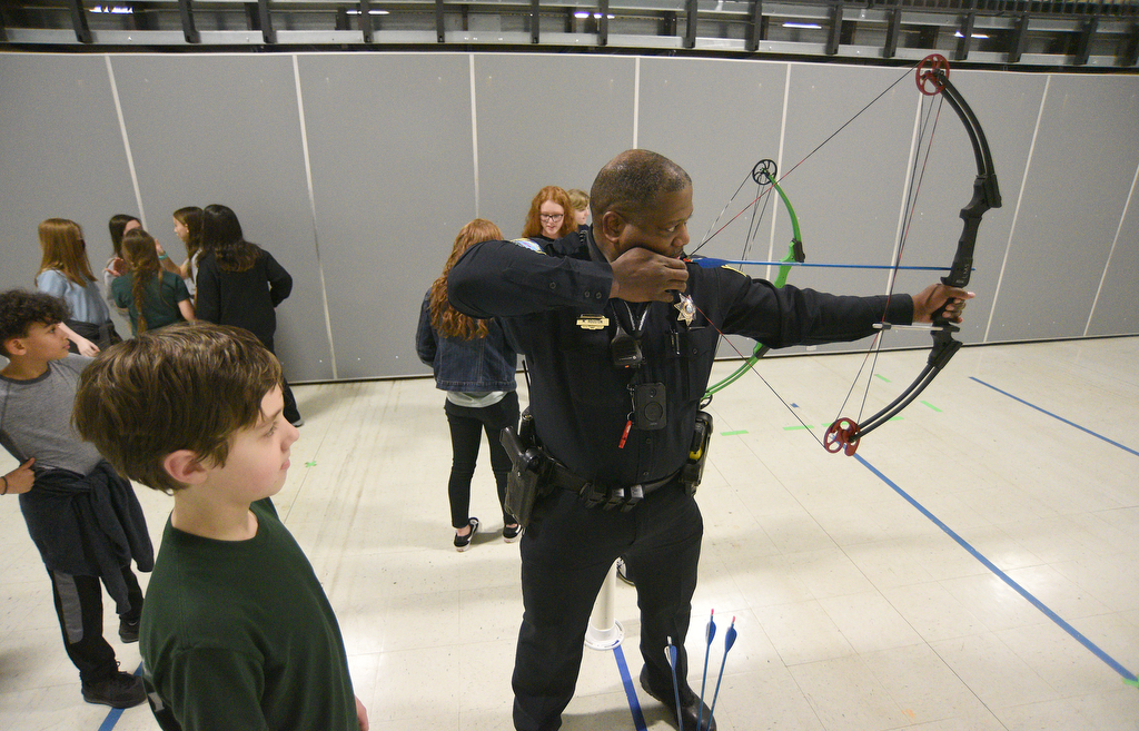 Staff Photo by Matt Hamilton / School resource officer Mike Houston demonstrates a proper stance to Logan Mabry, 11, during archery practice at Lofts Middle School in Hixson on Thursday, February 17, 2022.