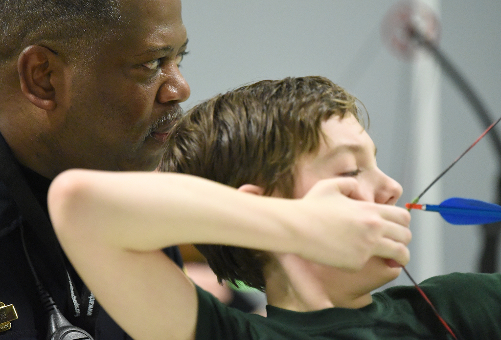 Staff Photo by Matt Hamilton / School resource officer Mike Houston watches as Logan Mabry, 11, aims an arrow during archery practice at Loftis Middle School in Hixson on Thursday, Feb. 17, 2022.