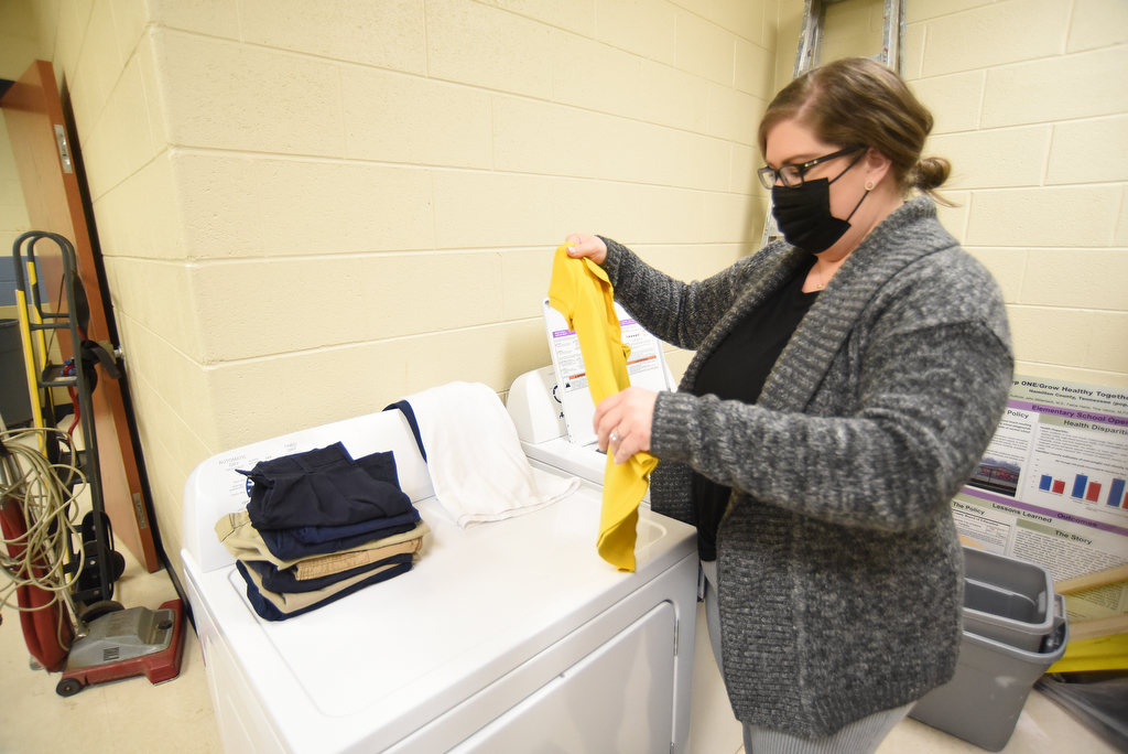 Staff Photo by Matt Hamilton / Community Forward School Coordinator Bailey Gibson uses the new washer and dryer at Orchard Knob Elementary School on Wednesday, Feb. 16, 2022.