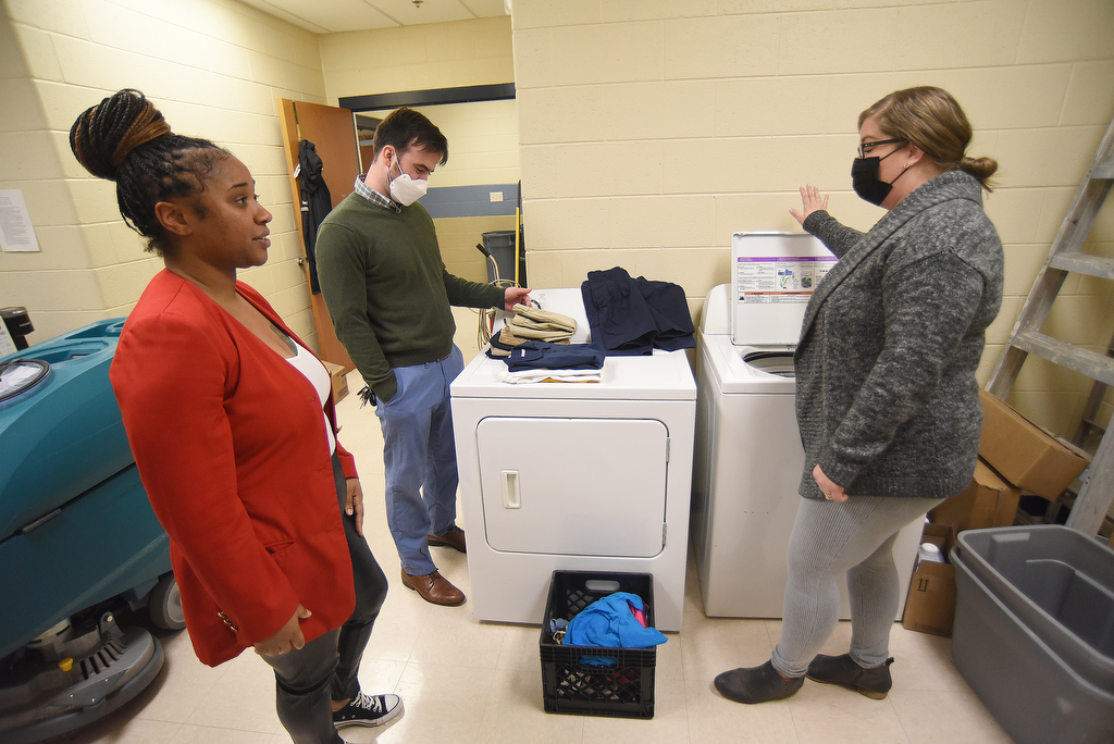 Staff Photo by Matt Hamilton / School counselors Dhyana Hodge, left, and James Moore talk with Community Forward School Coordinator Bailey Gibson about the new washer and dryer at Orchard Knob Elementary School on Wednesday, Feb. 16, 2022.