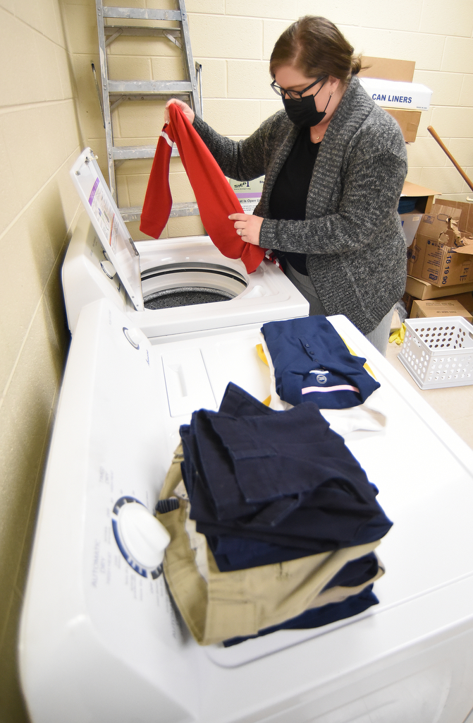 Staff Photo by Matt Hamilton / Community Forward School Coordinator Bailey Gibson uses the new washer and dryer at Orchard Knob Elementary School on Wednesday, Feb. 16, 2022.