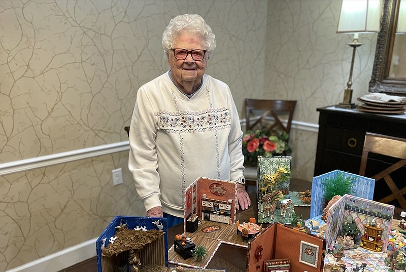 Staff photo by Mark Kennedy / Wilma Cale of Ooltewah shows off her breakaway boxes, a craft involving miniature scenes packed into cubes made of foam board and household items such as golf tees and thread spools.
