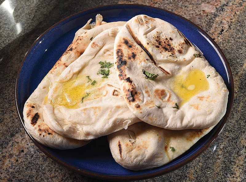 Staff Photo by Matt Hamilton / Butter melts on naan made by Sushma Shanta.