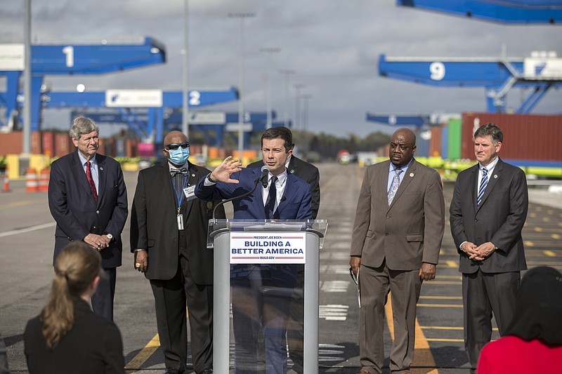 FILE - Transportation Secretary Pete Buttigieg speaks to the media during a visit to the Georgia Ports Authority's Megarail facility, on Dec., 17, 2021 in Savannah, Ga. Clogged U.S. ports are being given access to nearly $450 million in federal money from President Joe Biden's new infrastructure law, part of the administration's recent stepped-up efforts to ease supply chain congestion and lower prices for American consumers.(AP Photo/Stephen B. Morton, File)