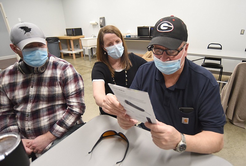 Staff Photo by Matt Hamilton / Cheryl Saucier, who owns Mountain View Low Vision Services, middle, demonstrates the OrCam MyEye Pro to Larry Houston, right, and Jacob Bailey, left, on Wednesday, January 26, 2022 at Lions Volunteer Blind Industries in Chattanooga.