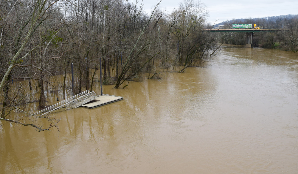 Staff Photo by Robin Rudd / A dock is surrounded by the flood waters of South Chickamauga Creek in the Tennessee Riverpark. In the background, traffic crosses a bridge on Amnicola Highway. The weather for Severe Weather Awareness Week has been an almost total washout as consecutive storm systems dumped rain on the Chattanooga region over the last several days. During the 48 hours from Feb. 21-23, Hamilton County got between 3.15 and 4.36 inches of rain.