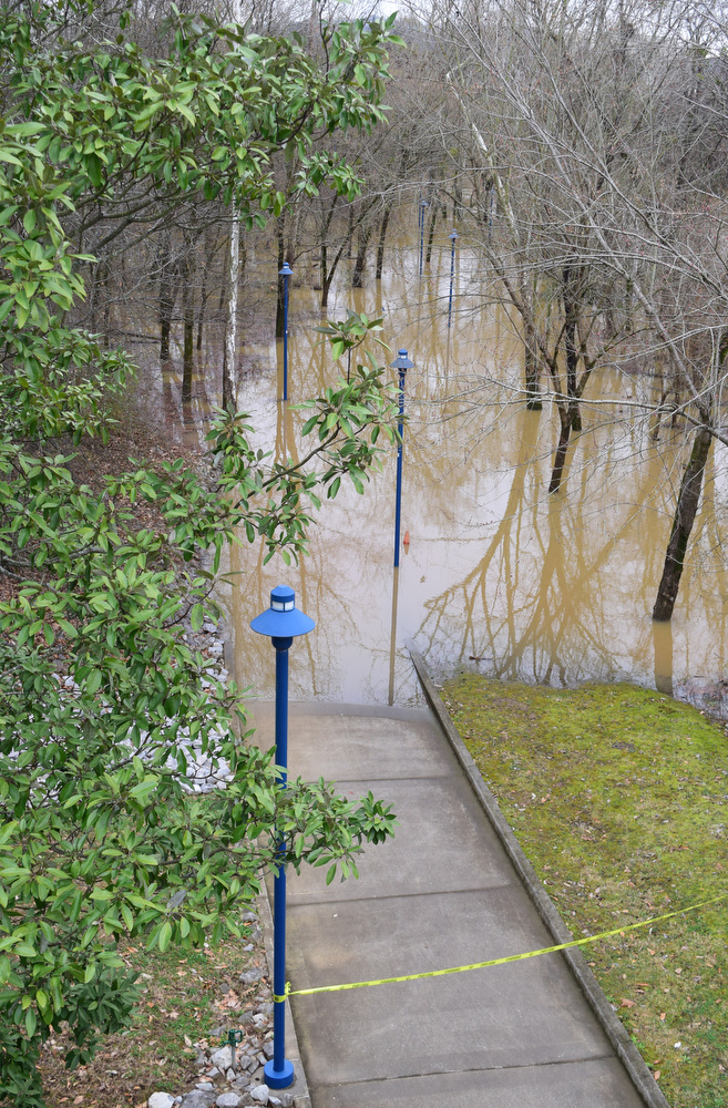 Staff Photo by Robin Rudd / Caution tape denies access to a flooded sidewalk along South Chickamauga Creek in the Tennessee Riverpark. The weather for Severe Weather Awareness Week has been an almost total washout as consecutive storm systems dumped rain on the Chattanooga region over the last several days. During the 48 hours from Feb. 21-23, Hamilton County got between 3.15 and 4.36 inches of rain.