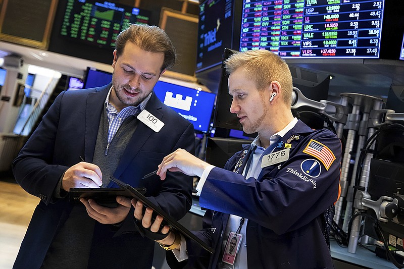 In this photo provided by the New York Stock Exchange, traders Ben Tuchman, left, and Colby Nelson work on the floor, Wednesday, March 2, 2022. Wall Street took another sharp swing Wednesday, this time back to rally mode, as stocks and Treasury yields rose even as oil prices continued to climb. (Allie Joseph/New York Stock Exchange via AP)
