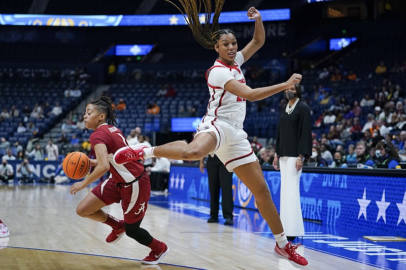 AP photo by Mark Humphrey / Georgia's Reigan Richardson, right, sails past Alabama's Megan Abrams in the first half of a second-round game at the SEC women's basketball tournament Thursday night at Bridgestone Arena in Nashville.