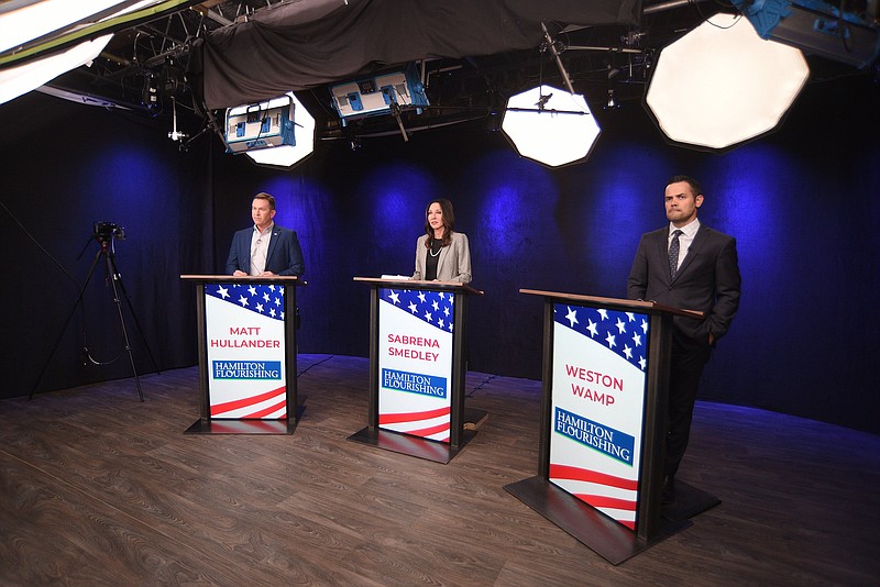 Staff Photo by Matt Hamilton / Candidates, from left, Matt Hullander, Sabrena Smedley and Weston Wamp stand behind their lecterns before the start of the Hamilton County Mayoral Republican Primary Debate on Monday, Feb. 21, 2022, at SociallyU Studio.