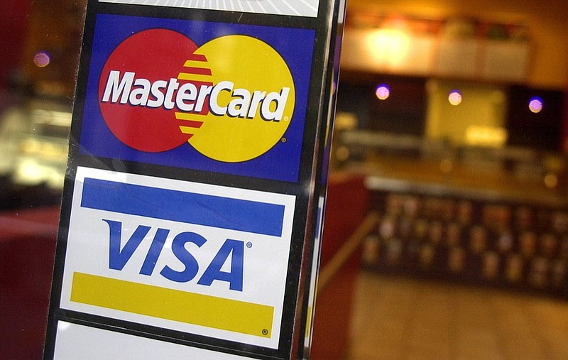 FILE - This April 22, 2005, file photo, shows logos for MasterCard and Visa credit cards at the entrance of a New York coffee shop. (AP Photo/Mark Lennihan, File)



