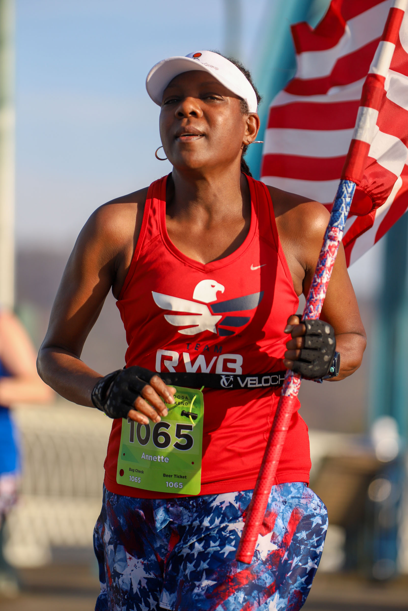 Staff Photo by Olivia Ross / Annette Tolliver carries an American flag as she runs across the Walnut Street Bridge on March 6, 2022. The Erlanger Chattanooga Marathon is a full weekend complete with a marathon, half marathon, relays, 5k, and kid's fun run.