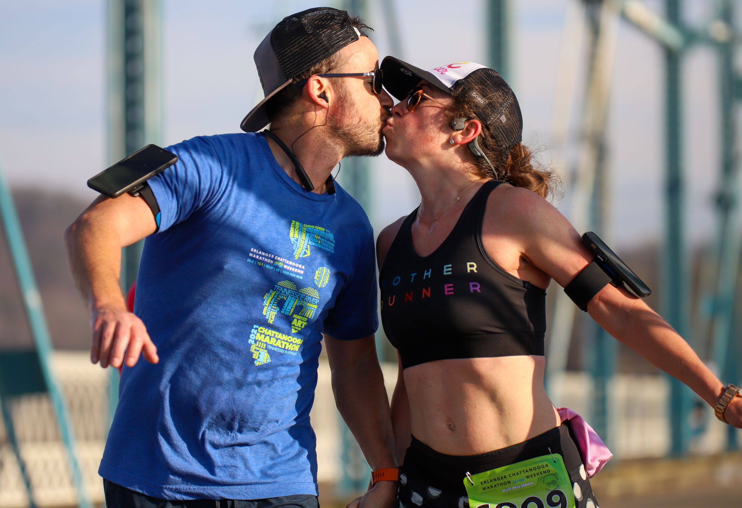 Staff Photo by Olivia Ross /  John and Chloe Ciliege share a kiss while running across the Walnut Street Bridge on March 6, 2022. The Erlanger Chattanooga Marathon is a full weekend complete with a marathon, half marathon, relays, 5k, and kid's fun run.