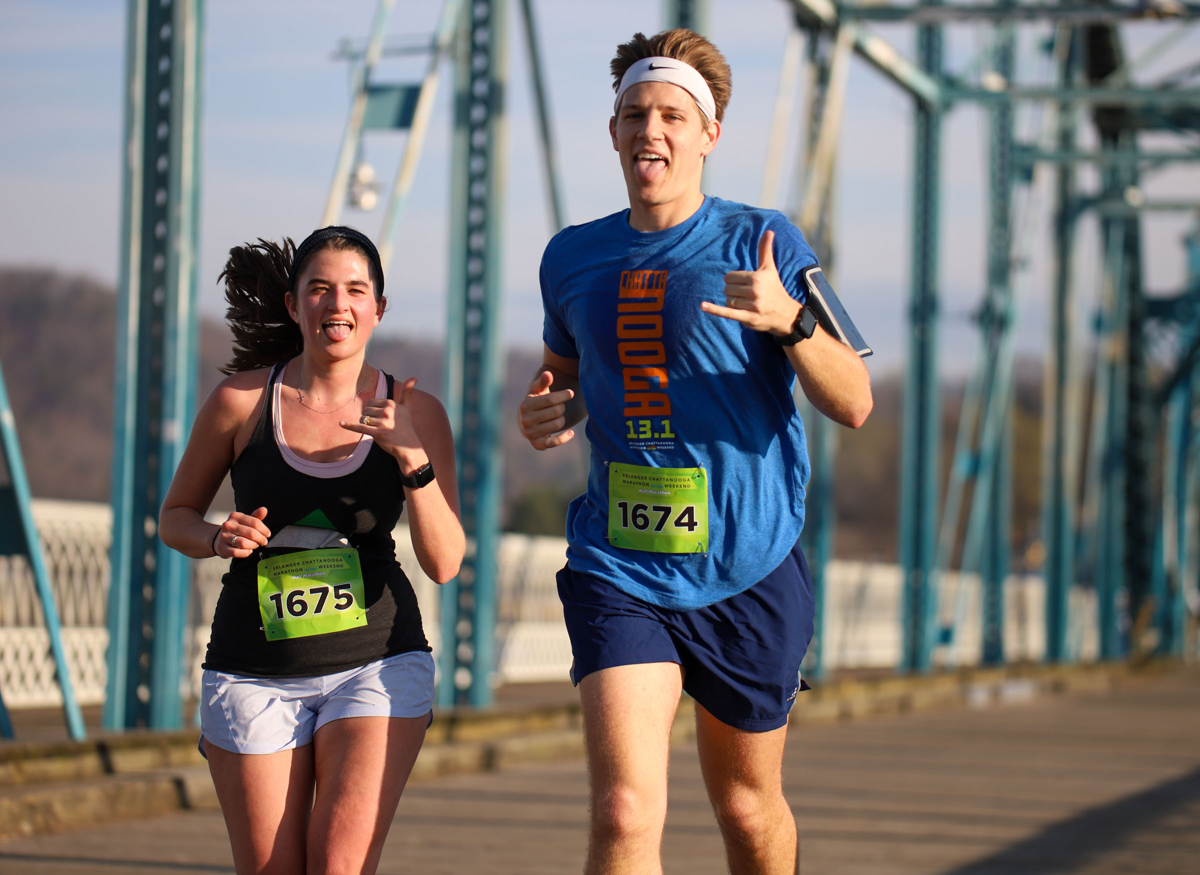 Staff Photo by Olivia Ross / Maria and Ryan Rhodes pose as they run across the Walnut Street Bridge on March 6, 2022. The Erlanger Chattanooga Marathon is a full weekend complete with a marathon, half marathon, relays, 5k, and kid's fun run.