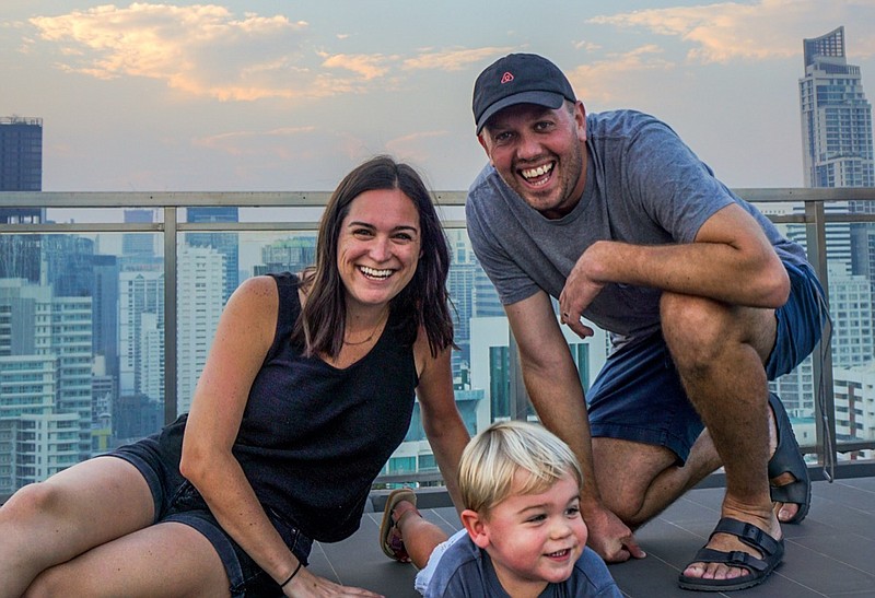 Contributed photo by Stephanie Hays. Stephanie Hays, her husband, Peter Woolcock, and their 2-year-old son, Hays, pose on a roof in Bangkok, Thailand. The family is on a worldwide trip as part of a promotion called "Live Anywhere on Airbnb."