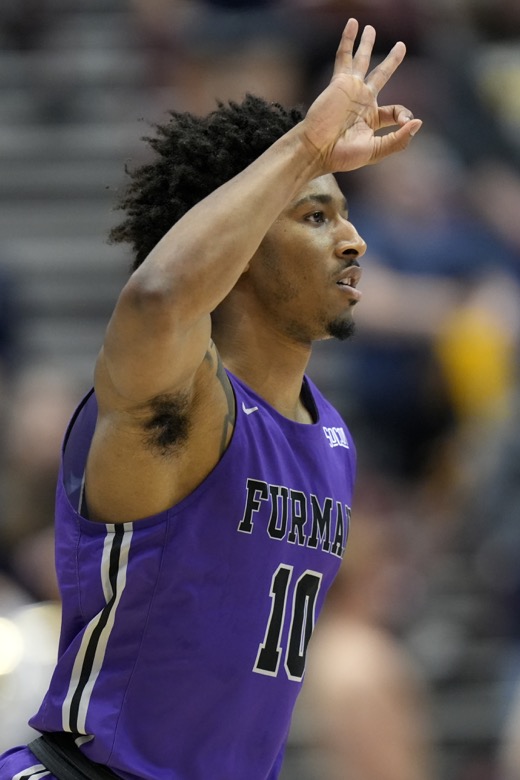 Furman guard Alex Hunter (10) gestures after shooting a 3-pointer against Chattanooga in the first half of an NCAA college basketball championship game for the Southern Conference tournament, Monday, March 7, 2022, in Asheville, N.C. (AP Photo/Kathy Kmonicek)