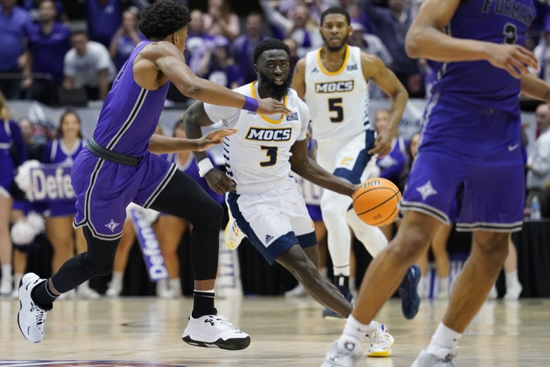 Chattanooga guard David Jean-Baptiste (3) drives the ball past Furman guard Marcus Foster (5) to shoot the winning basket in an NCAA college basketball championship game for the Southern Conference tournament, Monday, March 7, 2022, in Asheville, N.C. (AP Photo/Kathy Kmonicek)