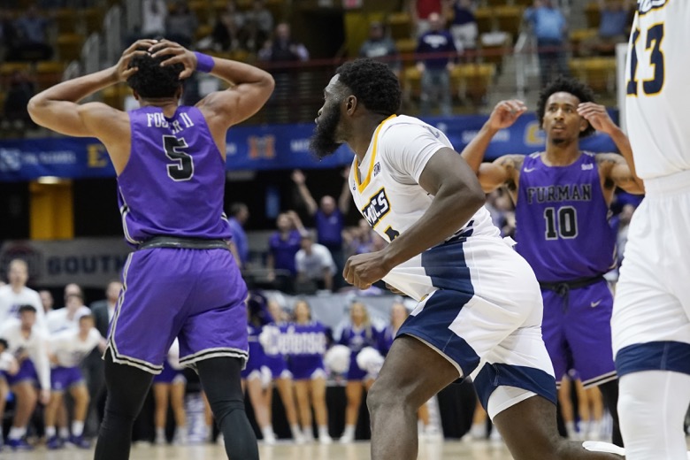 Furman guard Marcus Foster (5) and Furman guard Alex Hunter (10) react after Chattanooga guard David Jean-Baptiste (3) shot the winning basket in an NCAA college basketball championship game for the Southern Conference tournament, Monday, March 7, 2022, in Asheville, N.C. (AP Photo/Kathy Kmonicek)