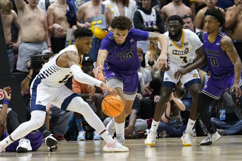 Chattanooga guard Malachi Smith (13) grabs the ball ahead of Furman forward Jalen Slawson (20) as Chattanooga guard David Jean-Baptiste (3) and Furman guard Alex Hunter (10) look on in the second half of an NCAA college basketball championship game for the Southern Conference tournament, Monday, March 7, 2022, in Asheville, N.C. (AP Photo/Kathy Kmonicek)
